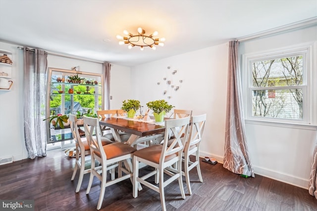 dining area featuring dark wood-style floors, baseboards, and an inviting chandelier