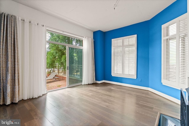 unfurnished room featuring wood finished floors and baseboards