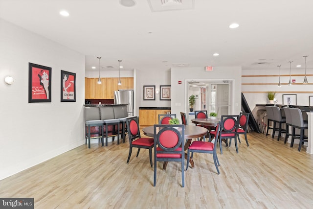 dining area featuring light wood-style flooring, baseboards, and recessed lighting