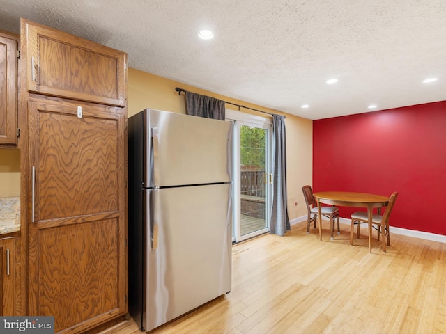 653 Willowby Run, Pasadena, MD 21122 - kitchen featuring recessed lighting, a textured ceiling, light wood-type flooring, and freestanding refrigerator
