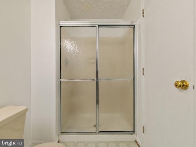 653 Willowby Run, Pasadena, MD 21122 - bathroom featuring baseboards, toilet, a textured ceiling, and a stall shower