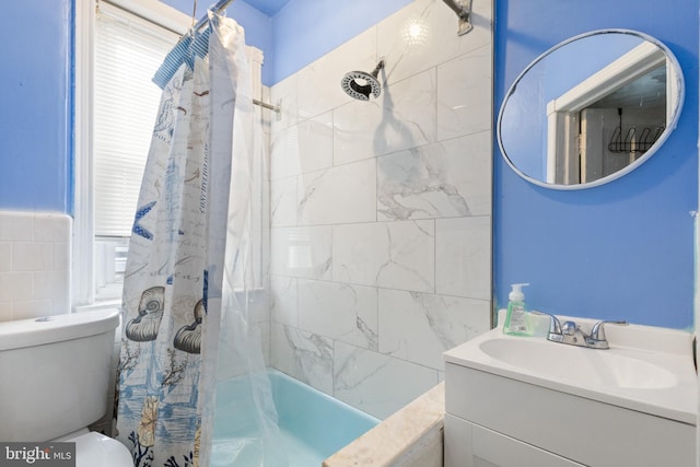full bathroom with tile walls, shower / bath combo, vanity, and toilet