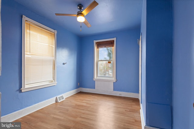 unfurnished room with visible vents, baseboards, a ceiling fan, and wood finished floors