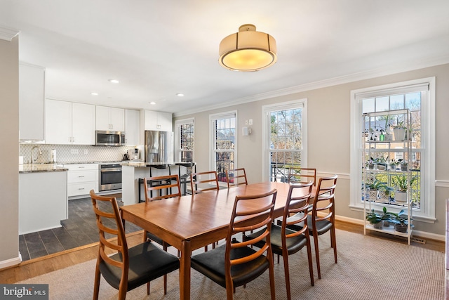 dining space featuring recessed lighting, ornamental molding, and dark wood-style floors
