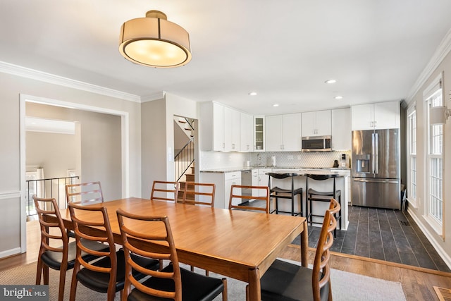 dining space with crown molding, recessed lighting, stairway, and dark wood-type flooring