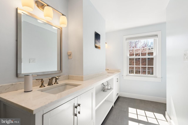 bathroom featuring double vanity, baseboards, and a sink