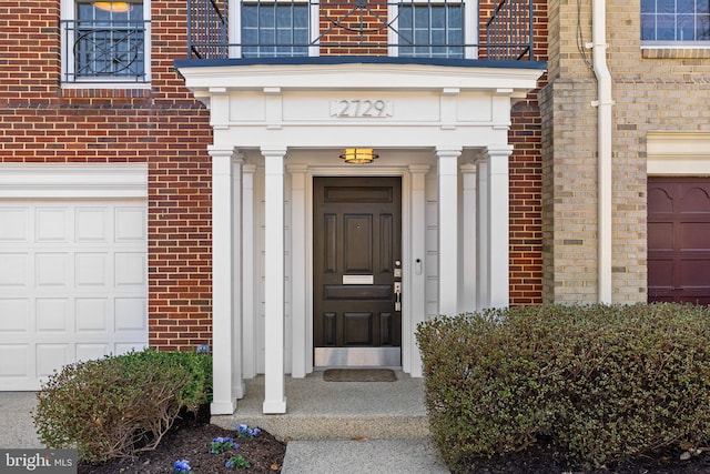 property entrance with brick siding and an attached garage