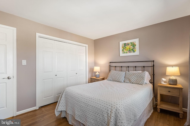 bedroom with baseboards, a closet, and wood finished floors