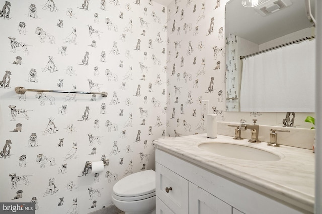 full bath with toilet, wallpapered walls, visible vents, and vanity