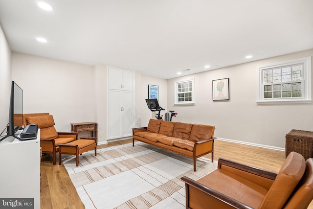 living area featuring recessed lighting, baseboards, and light wood-type flooring