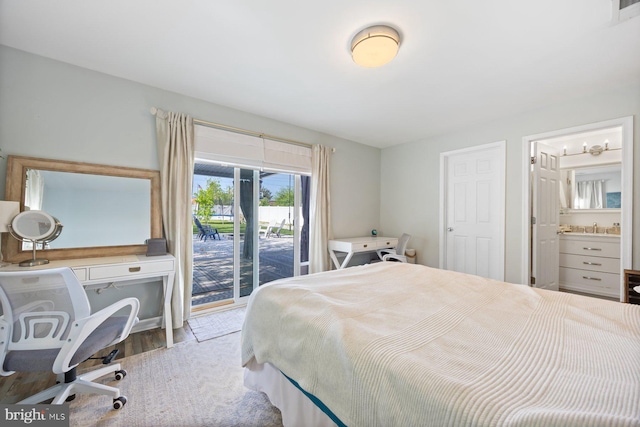 bedroom with visible vents, access to exterior, wood finished floors, a sink, and ensuite bathroom