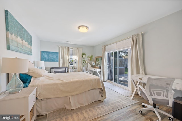 bedroom featuring access to outside, multiple windows, and light wood-type flooring