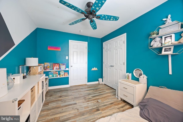 bedroom with a closet, baseboards, ceiling fan, and wood finished floors