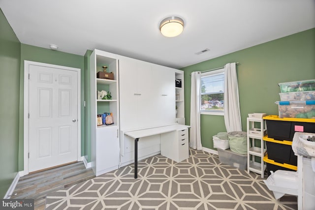 office space featuring baseboards and visible vents