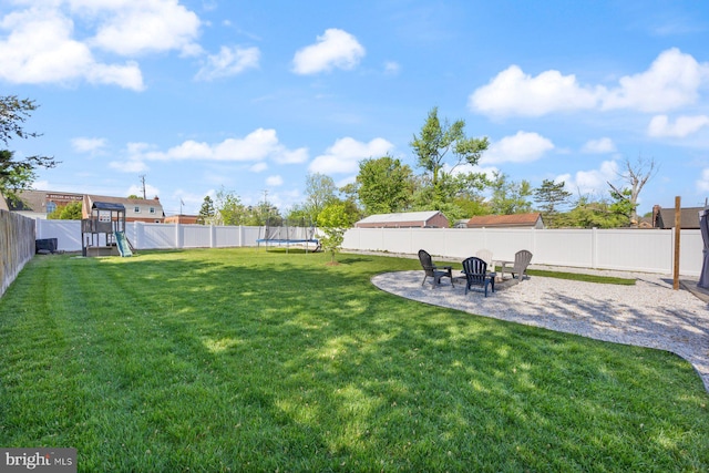 view of yard with a patio, a fenced backyard, a trampoline, and a playground