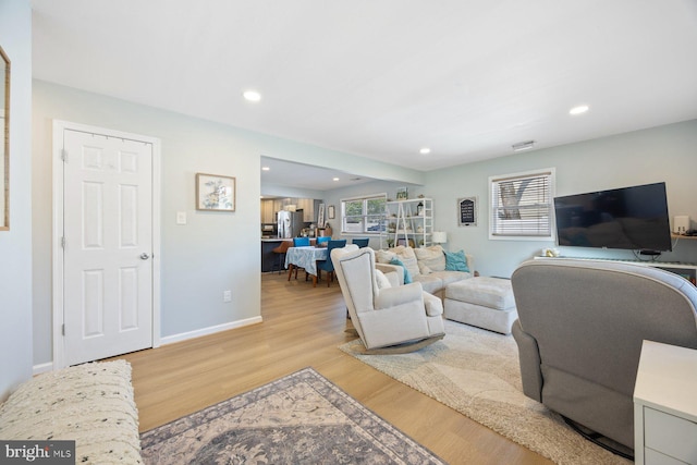 living area featuring recessed lighting, baseboards, and light wood-style floors