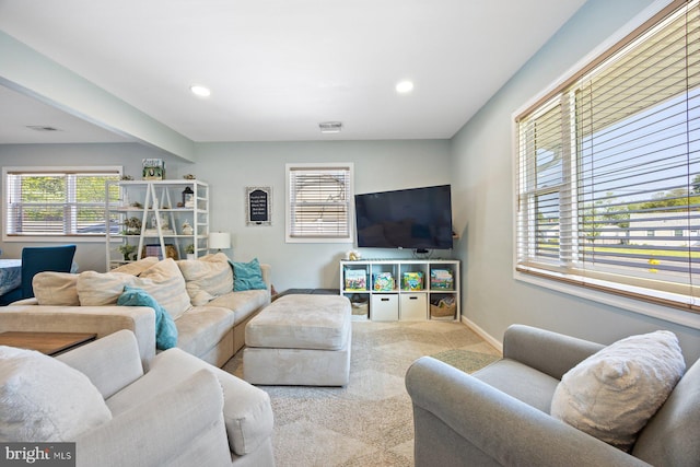 carpeted living room with baseboards, recessed lighting, a healthy amount of sunlight, and visible vents