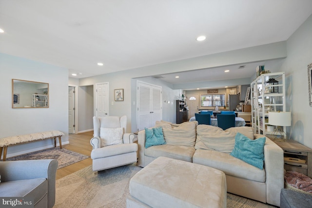 living area featuring recessed lighting, light wood finished floors, and baseboards