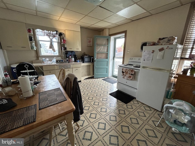 919 S Queen St, York, PA 17403 - kitchen featuring a drop ceiling, light countertops, white appliances, and a wealth of natural light
