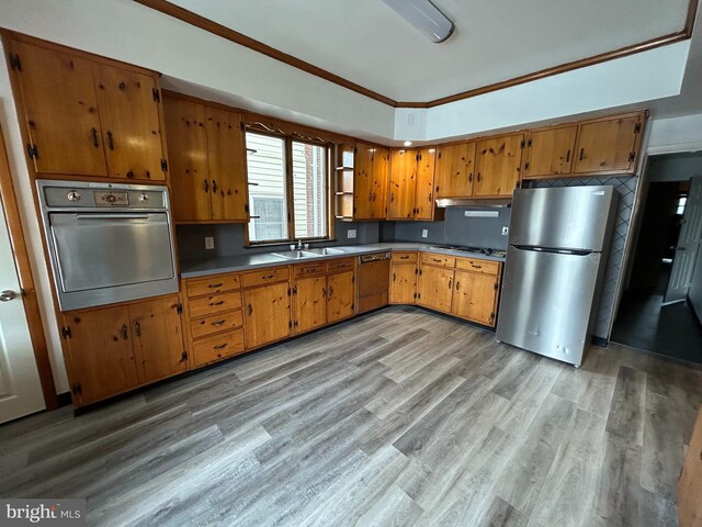 919 S Queen St, York, PA 17403 - kitchen featuring under cabinet range hood, brown cabinetry, stainless steel appliances, light wood finished floors, and a sink