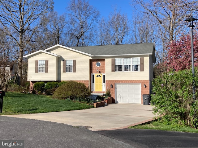 raised ranch with a front lawn, brick siding, an attached garage, a shingled roof, and driveway