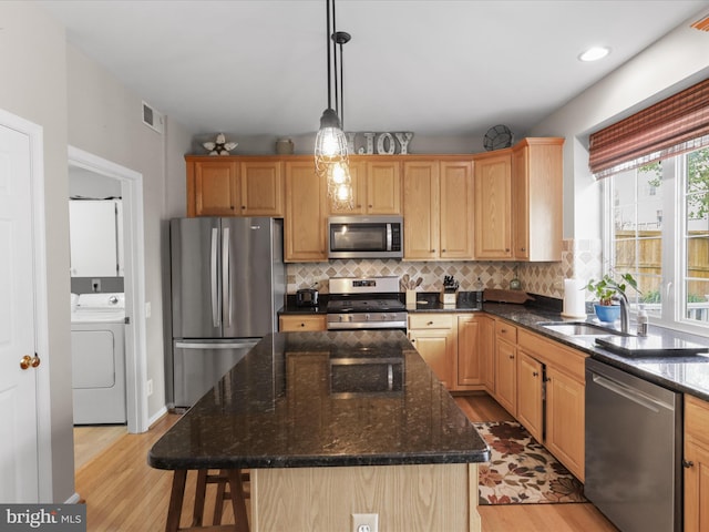 kitchen featuring tasteful backsplash, light wood-style floors, washer / dryer, visible vents, and appliances with stainless steel finishes