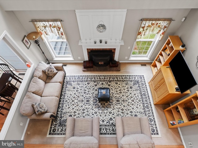 living area featuring visible vents, baseboards, and a brick fireplace