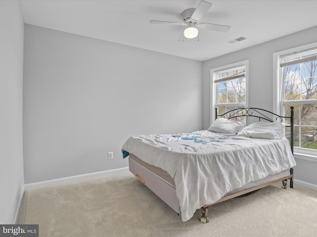 bedroom with light colored carpet, baseboards, a ceiling fan, and visible vents