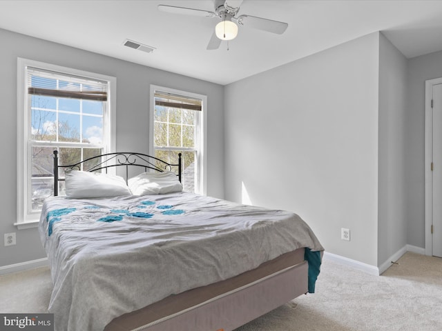 carpeted bedroom with baseboards, a ceiling fan, and visible vents