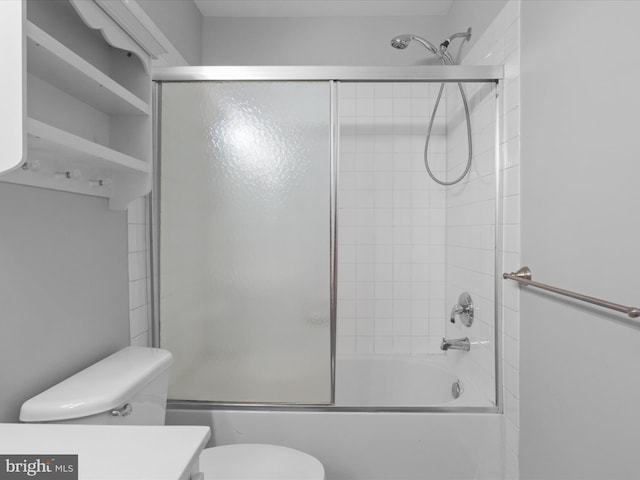 bathroom with toilet, combined bath / shower with glass door, and vanity