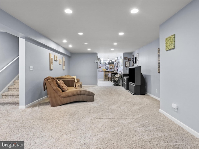 living area featuring carpet flooring, stairs, baseboards, and recessed lighting