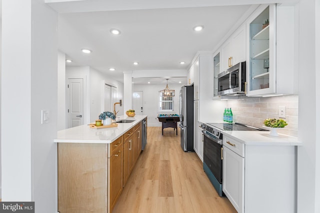 615 Salt Spray Rd Unit 3E, Ocean City, MD 21842 - kitchen with light wood-type flooring, white cabinets, appliances with stainless steel finishes, a kitchen island with sink, and a sink