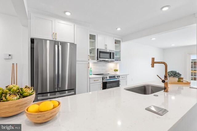 615 Salt Spray Rd Unit 3E, Ocean City, MD 21842 - kitchen featuring glass insert cabinets, a sink, white cabinetry, stainless steel appliances, and light stone counters