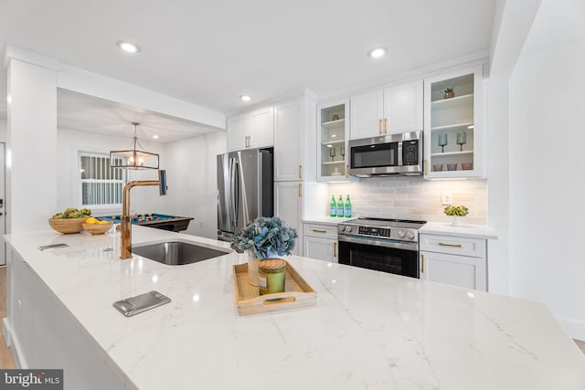 615 Salt Spray Rd Unit 3E, Ocean City, MD 21842 - kitchen with light stone countertops, white cabinetry, a sink, stainless steel appliances, and decorative backsplash