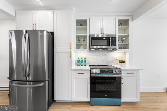 615 Salt Spray Rd Unit 3E, Ocean City, MD 21842 - kitchen featuring tasteful backsplash, light countertops, a baseboard radiator, white cabinetry, and stainless steel appliances
