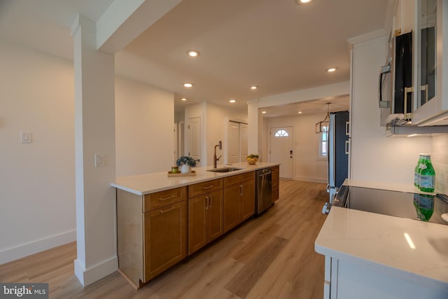 615 Salt Spray Rd Unit 3E, Ocean City, MD 21842 - kitchen with stainless steel appliances, brown cabinets, light wood-type flooring, and a sink
