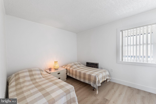 615 Salt Spray Rd Unit 3E, Ocean City, MD 21842 - bedroom featuring a textured ceiling, baseboards, heating unit, and wood finished floors