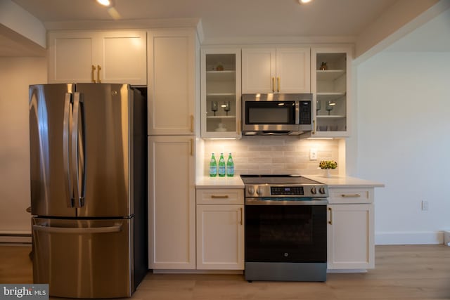615 Salt Spray Rd Unit 3E, Ocean City, MD 21842 - kitchen featuring glass insert cabinets, light countertops, backsplash, white cabinets, and appliances with stainless steel finishes