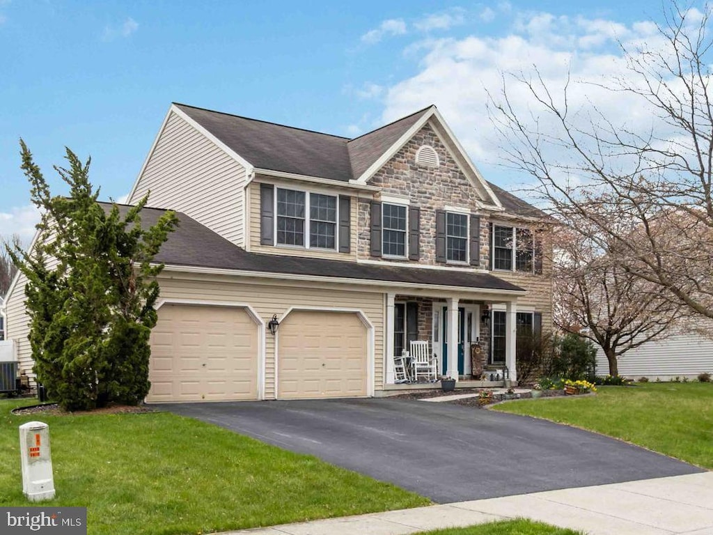 46 Wildflower Cir, Lebanon, PA 17046 - view of front of property featuring a front lawn, aphalt driveway, stone siding, covered porch, and cooling unit