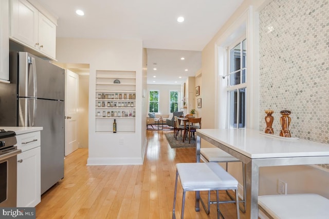1809 12th St NW, Washington, DC 20009 - kitchen with stainless steel appliances, white cabinets, light wood-type flooring, light countertops, and recessed lighting