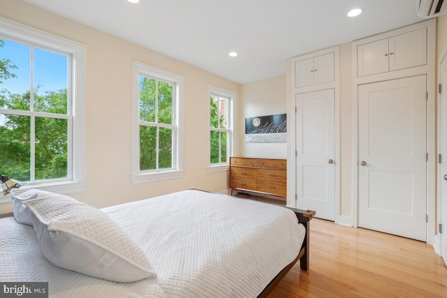 1809 12th St NW, Washington, DC 20009 - bedroom with a wall unit AC, multiple windows, recessed lighting, and light wood-style flooring