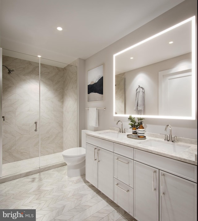 bathroom featuring a sink, toilet, a shower stall, and double vanity