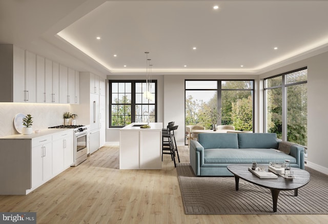 living area featuring recessed lighting, light wood-type flooring, baseboards, and a raised ceiling