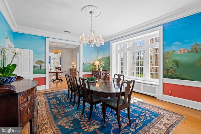dining space with visible vents, ornamental molding, a chandelier, and wood finished floors