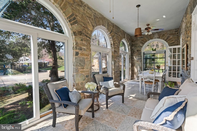sunroom with french doors, ceiling fan, and a towering ceiling