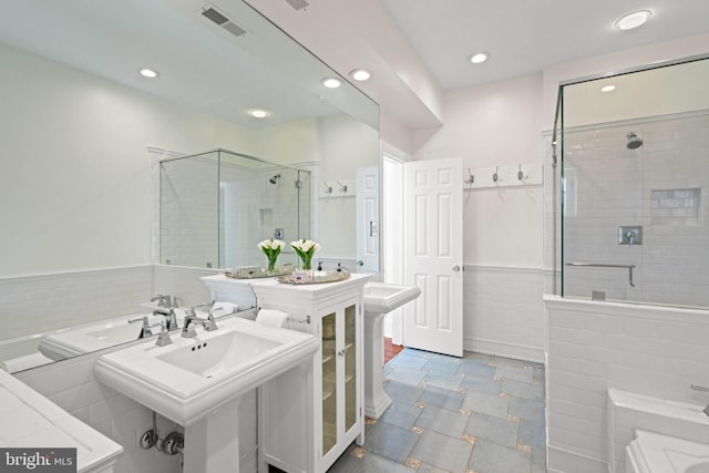 bathroom with visible vents, recessed lighting, a wainscoted wall, a sink, and a stall shower