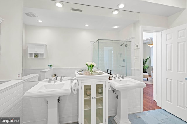 full bath with a stall shower, wainscoting, visible vents, and recessed lighting