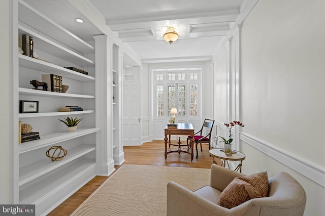 hallway with built in shelves and wood finished floors