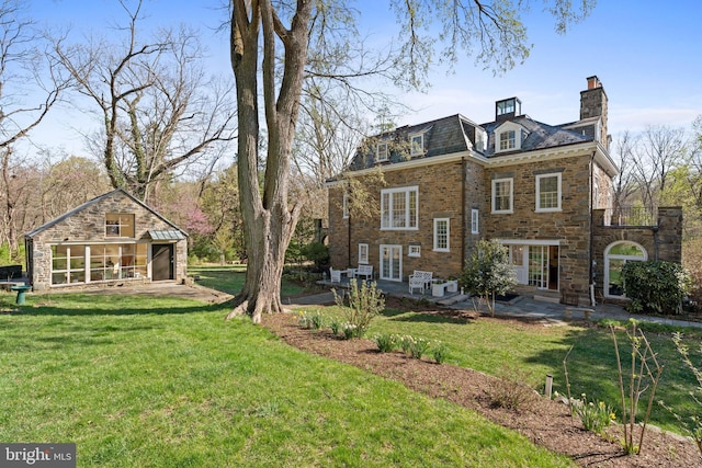 exterior space featuring a high end roof, a yard, a patio, and a chimney