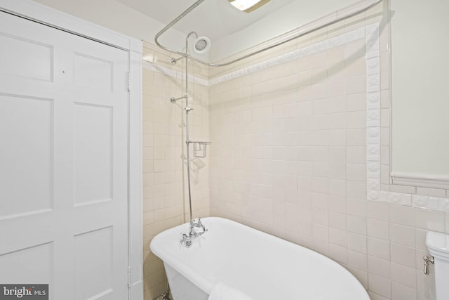 full bath featuring walk in shower, a freestanding bath, and tile walls